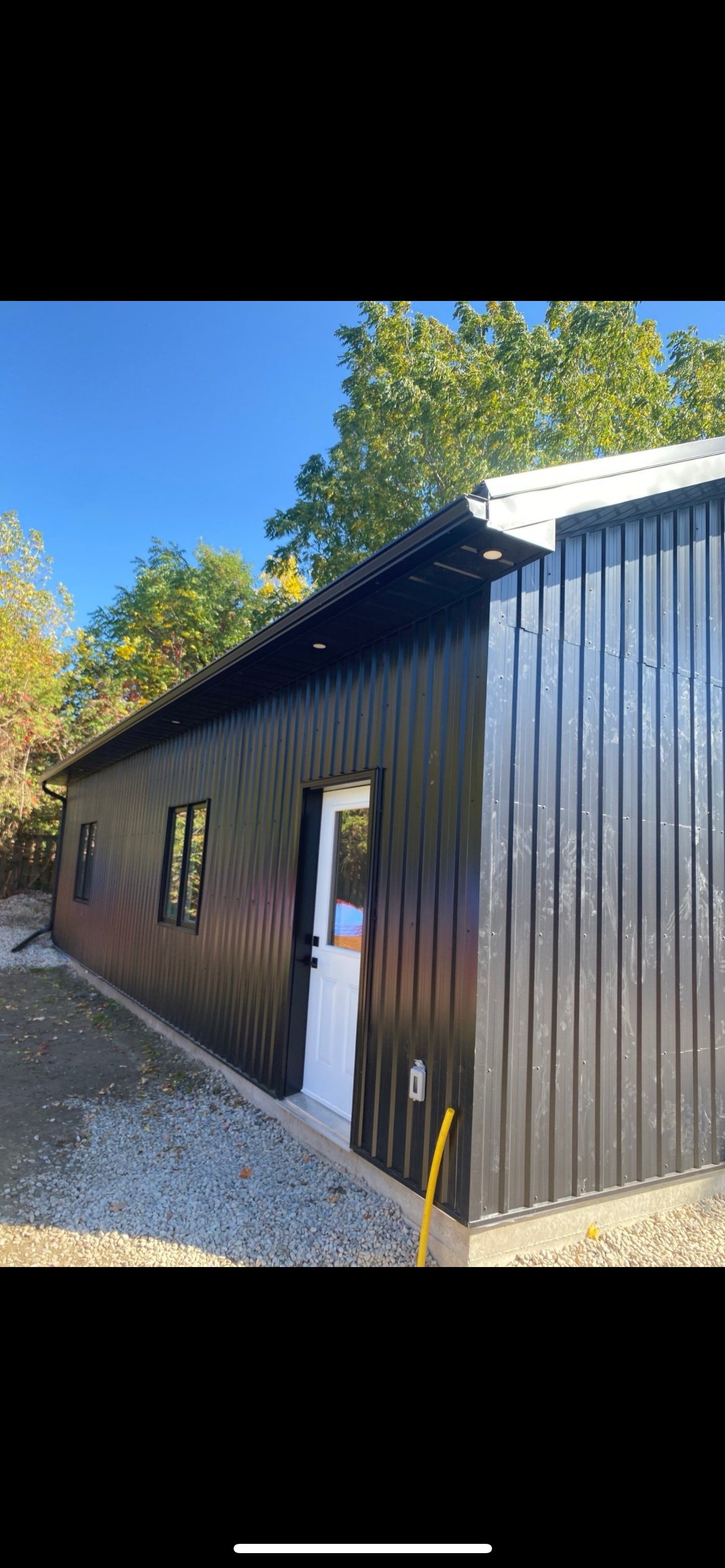 Completed black steel structure shop — side entry with soffit lighting